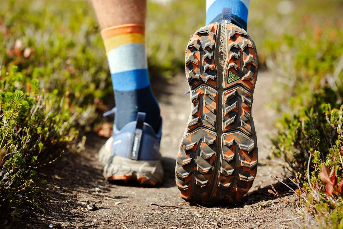 A close-up of a man wearing the best trail running shoes for men on a nature trail