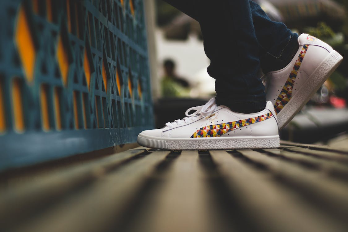 A person wearing Puma Clyde shoes for men, showcasing the stylish design and iconic Puma branding