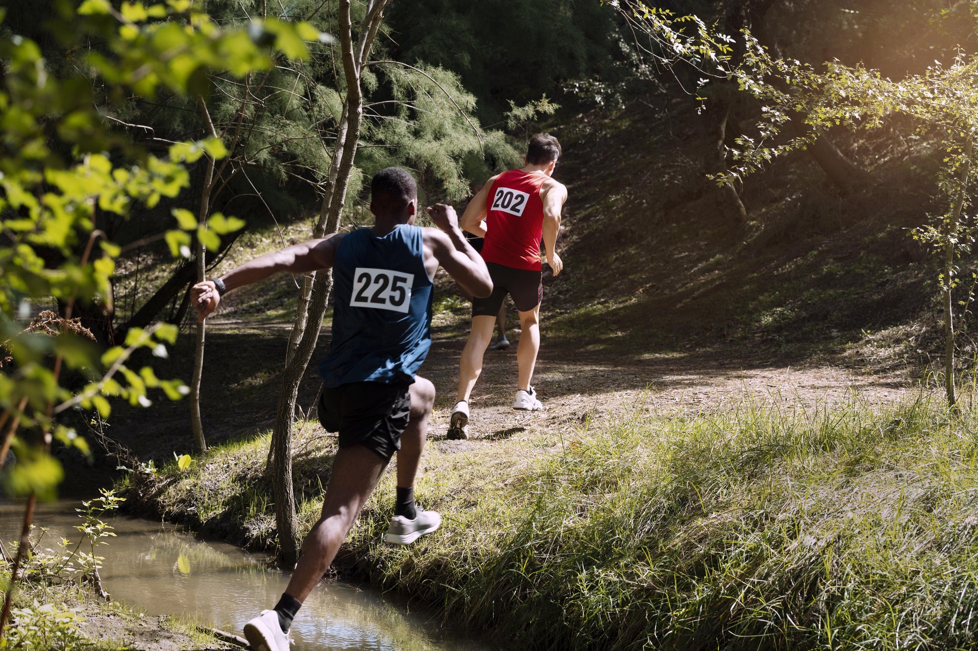 Two runners wearing the best pants for trail running during an uphill trail run.