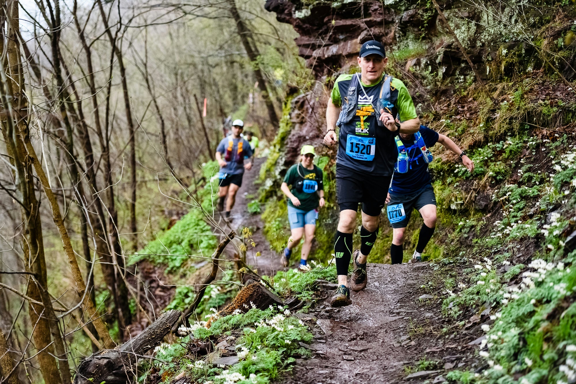 Trail runners geared up with hydration packs while running 