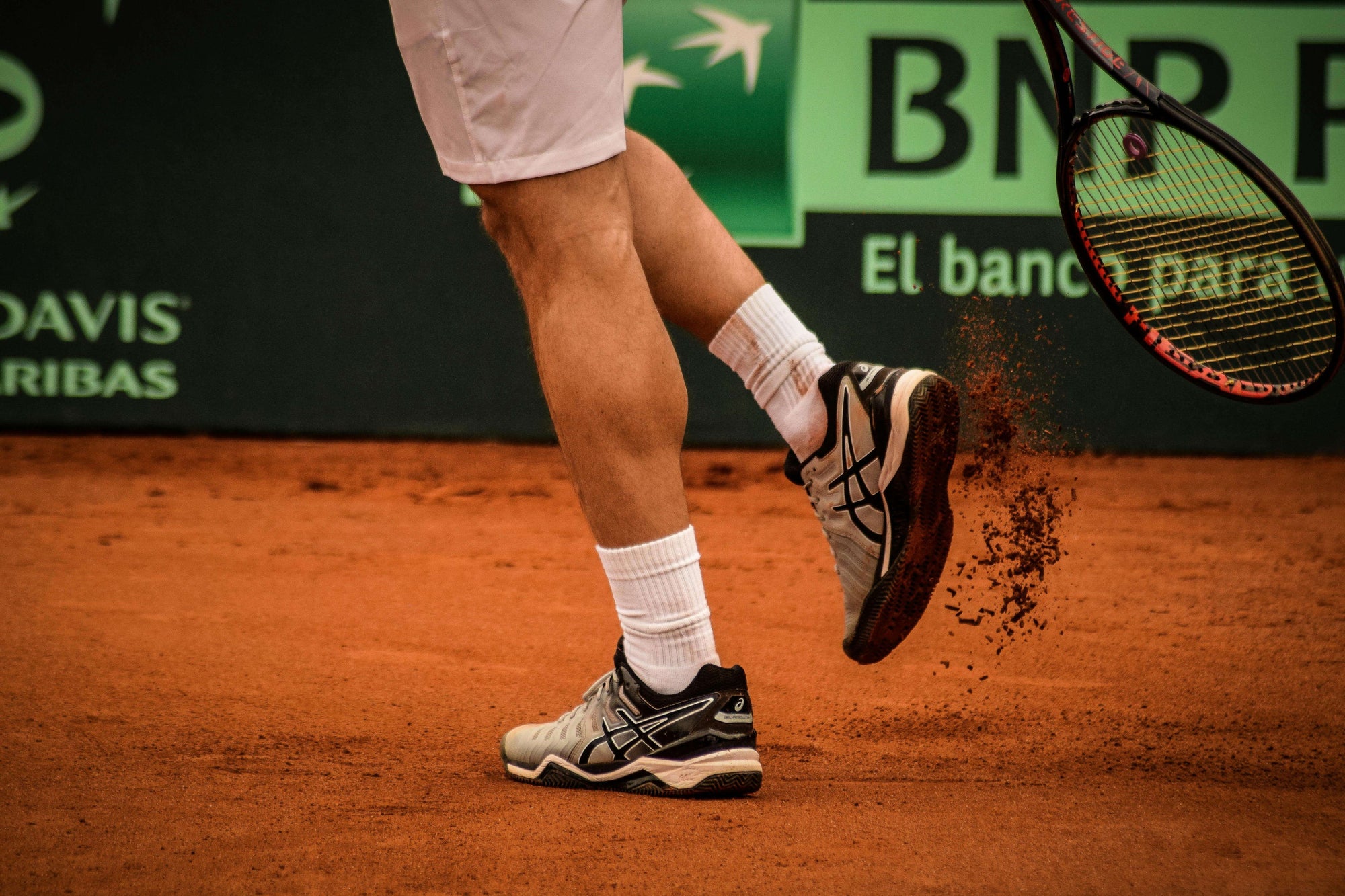 Tennis player on a tennis court wearing men's tennis shoes