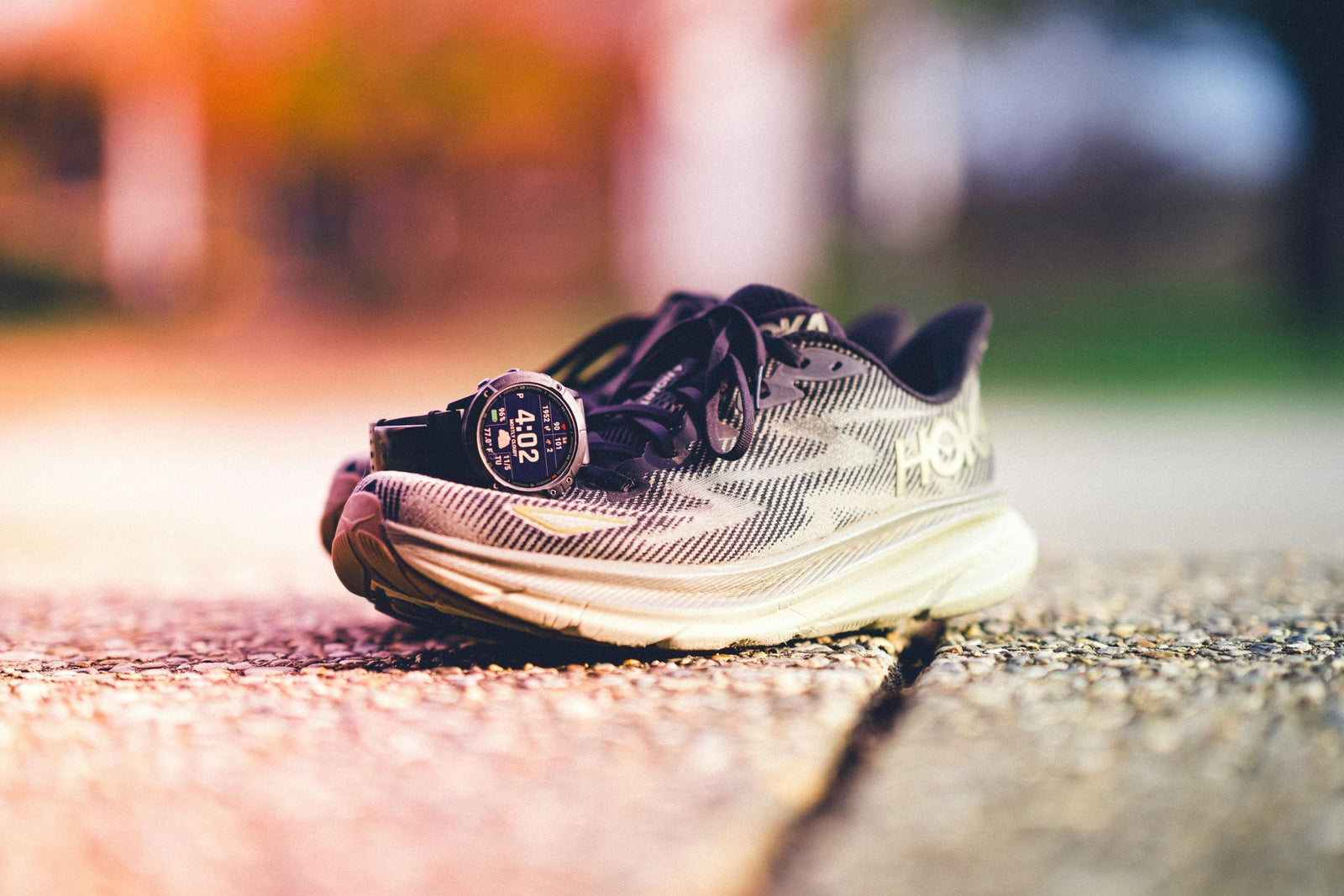 A smartwatch sitting on a pair of the best Hoka for road running