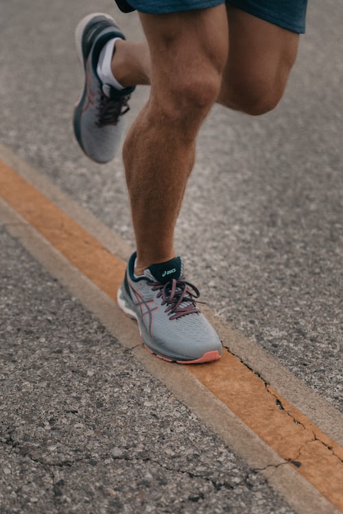 A person running with grey running shoes
