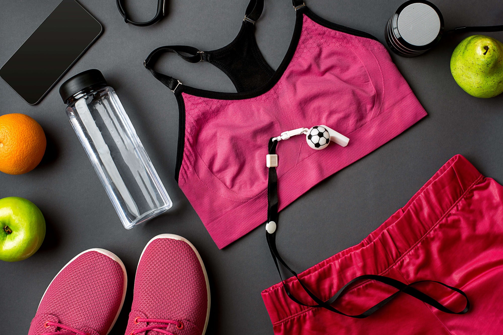 A shot of running equipment with running shoes, top, shorts, fitness watch, water bottle, and fruit