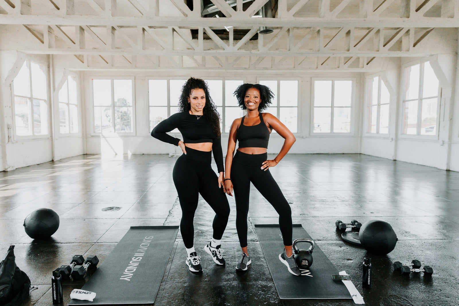Two smiling woman wearing essential women’s active wear while exercises