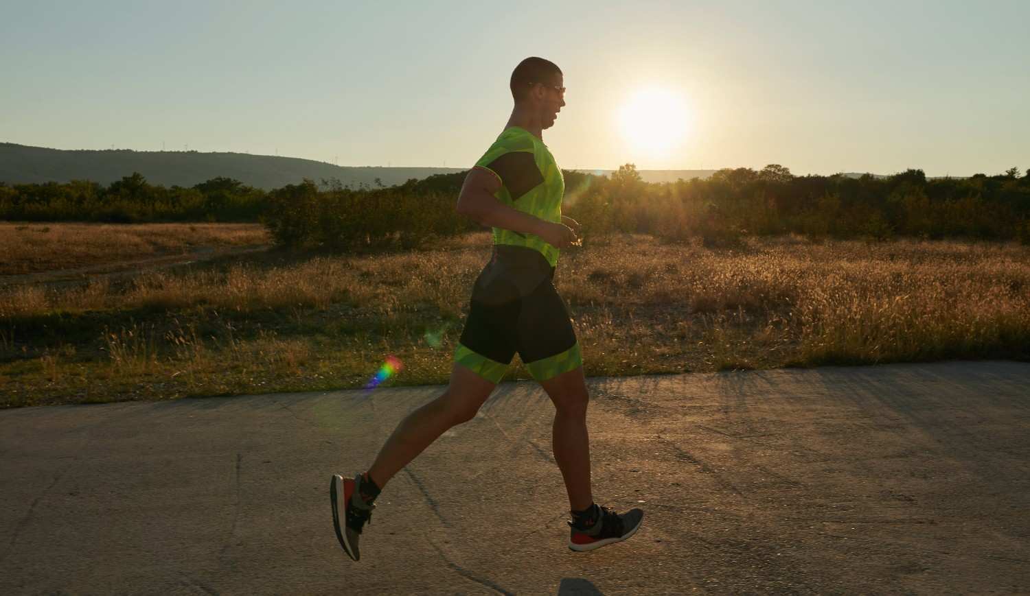 Men's running clothes in action during a morning run with the sun rising in the background